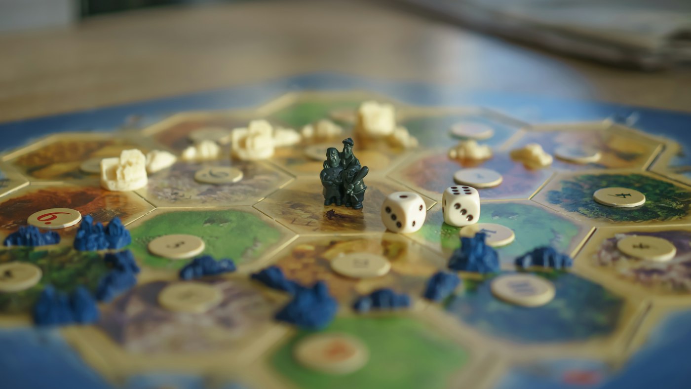 A board game mid-play on a sunlit table